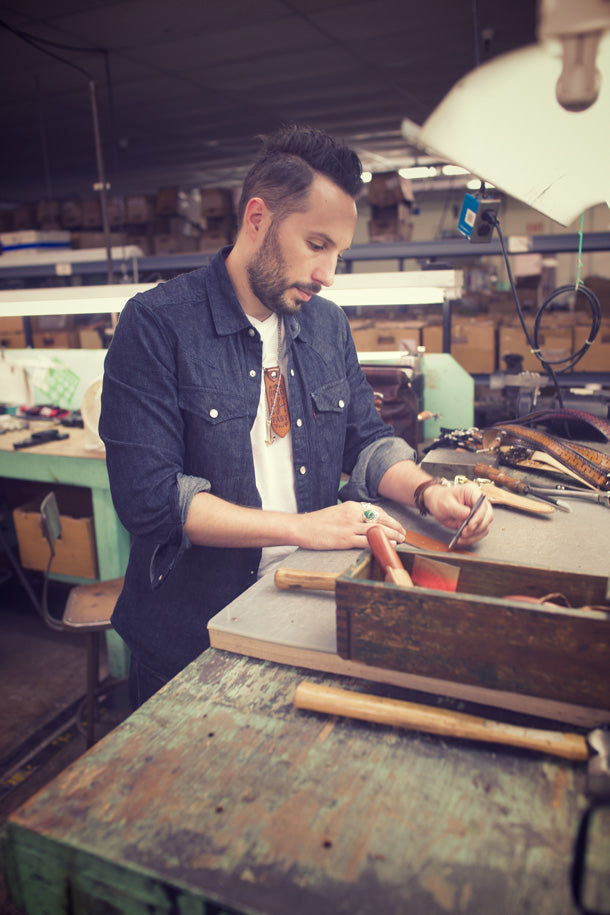 Man working on a project at a workbench in a workshop.